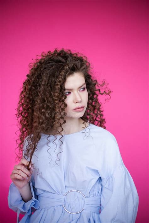 Fashion Model Girl With Curly Wavy Shiny Healthy Hair On Pink