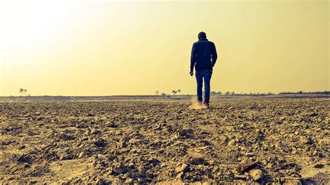 Man Walking In A Desert Backiee