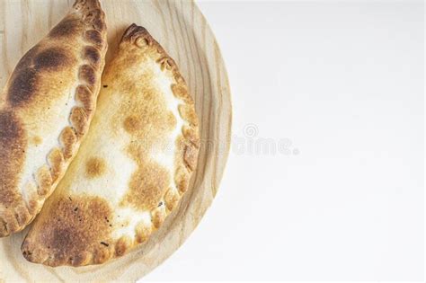 Delicious Argentine Empanadas On A Wooden Board On A White Background