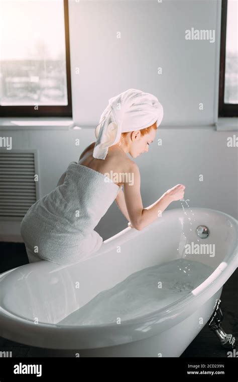 morning routine of redhead beauty in the bathroom woman running bath wants to refresh in the