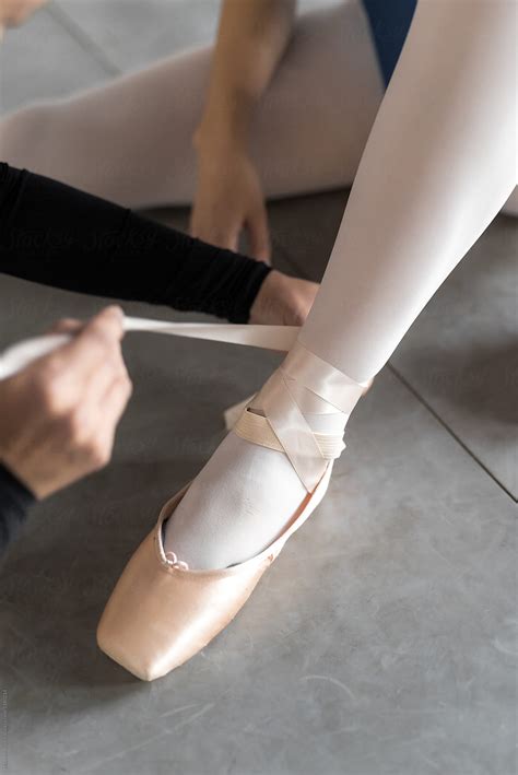 ballerinas helping each other putting on ballet slippers by stocksy contributor maahoo stocksy