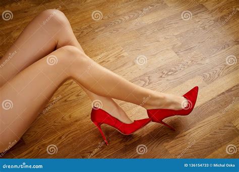Le Gambe Della Donna Sexy Lunga In Tacchi Alti Rossi Sul Pavimento Di Legno Immagine Stock