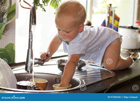 Cute Toddler Boy Washing Dishes In Domestic Kitchen Adorable Baby Boy