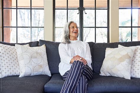 Portrait Of Mature Woman With Grey Hair Laughing In Her Living Room At