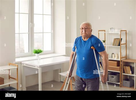 Senior Person With Broken Leg Or Physical Disability Walking With