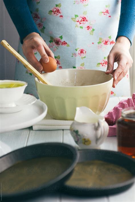 Woman Cracking Egg Into Mixing Bowl To Make Chocolate Cake Del Colaborador De Stocksy Kirsty
