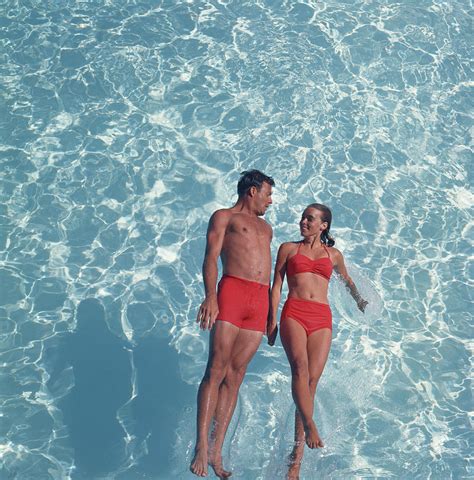 Young Couple Jumping In Swimming Pool Photograph By Tom Kelley Archive