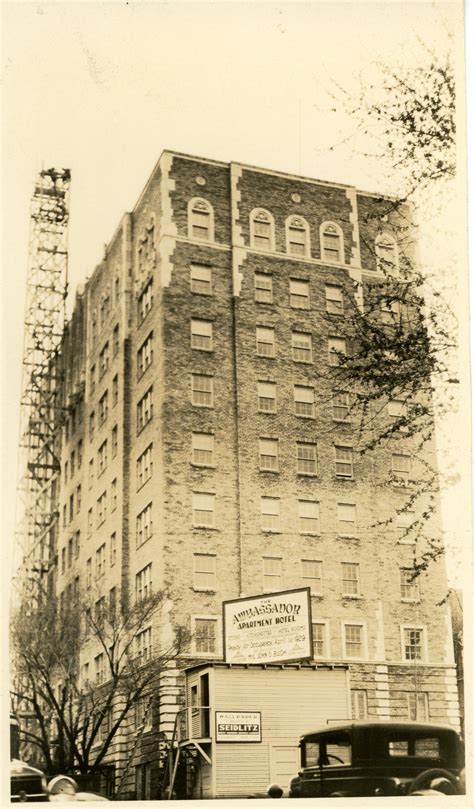 An Old Black And White Photo Of A Building With Cars Parked In Front Of It