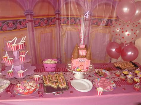 A Pink Table Topped With Lots Of Food And Desserts Next To Balloon