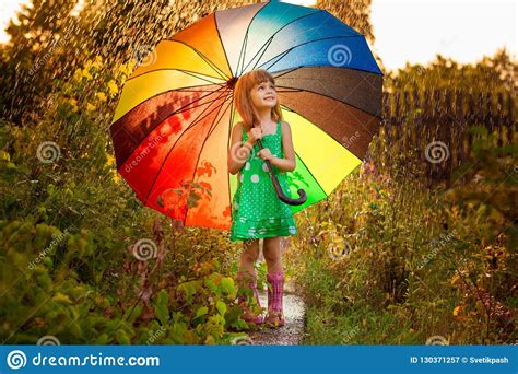 Happy Child Girl Walk With Multicolored Umbrella Under