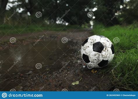 Dirty Leather Soccer Ball Near Puddle Outdoors Space For Text Stock