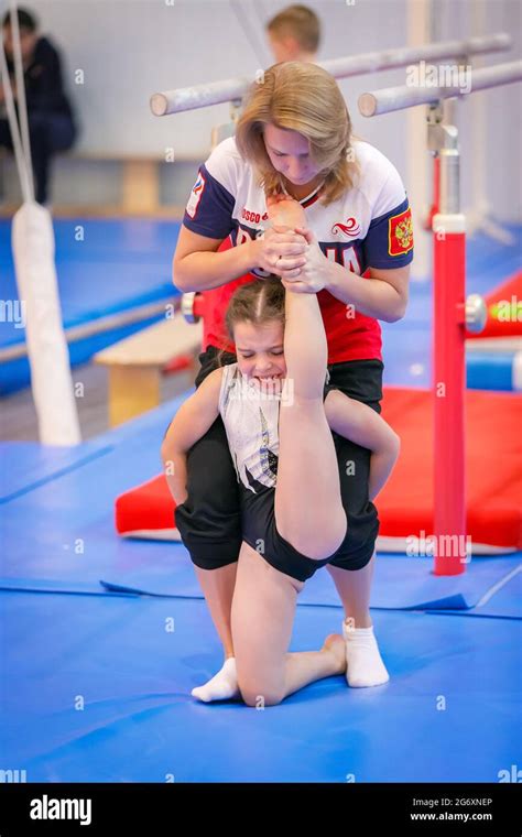 Gymnastics Coach Stretches A Young Athlete In The Gym Stretching The Legs And Arms The Coach