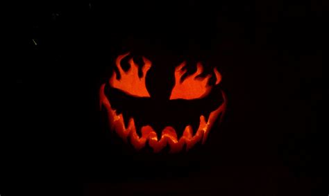 A Carved Pumpkin With Flames On Its Face