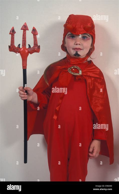Little Girl Dressed Up In Red Devil Costume For Halloween Stock Photo