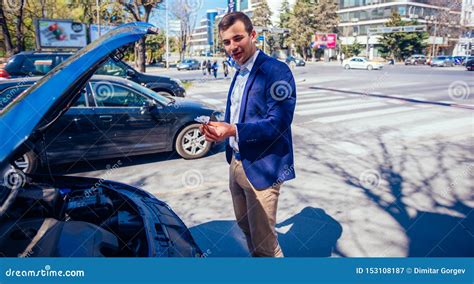 A Businessman Has Parked His Car At The Side Of The Boulevard While He