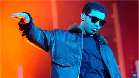 Drake In Orange Red Background Wearing Black Jacket And Goggles Hd