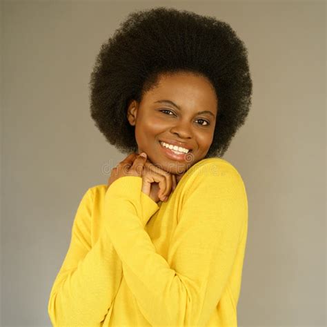Happy Afro American Millennial Woman With Afro Hair Style Wear Yellow Sweater Posing Over Grey