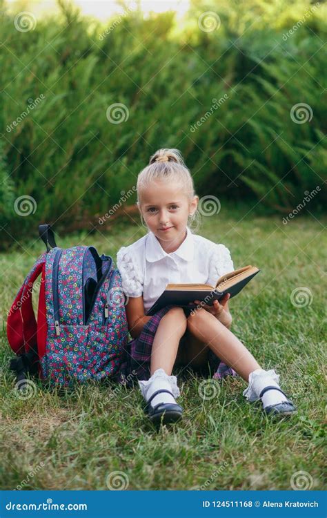 Het Meisje Zit Op Het Gras En Leest Boek Leerlingen Van Lage School Begin Van Lessen Eerste Dag