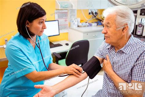 Female Doctor Checking Blood Pressure Of Patient Stock Photo Picture