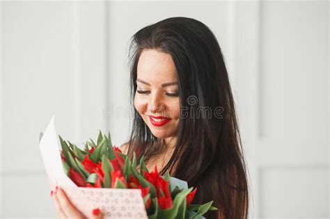 Beautiful Caucasian Brunette Woman Holding Fresh Blossoming Red Tulips