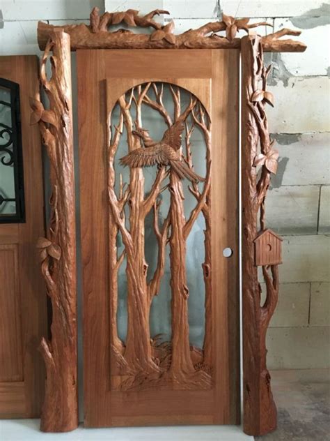 A Wooden Door With Carvings On The Sides And An Eagle In The Tree Above It