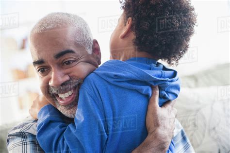 Close Up Of Mixed Race Grandfather And Grandson Hugging Stock Photo