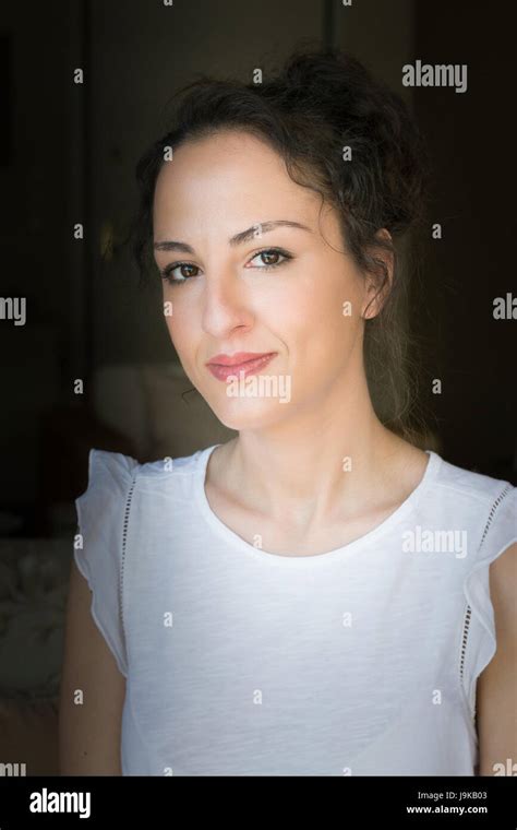 Portrait Of A Woman Of 31 Years Old With Updo Hair Looking At Camera In A Confident Way