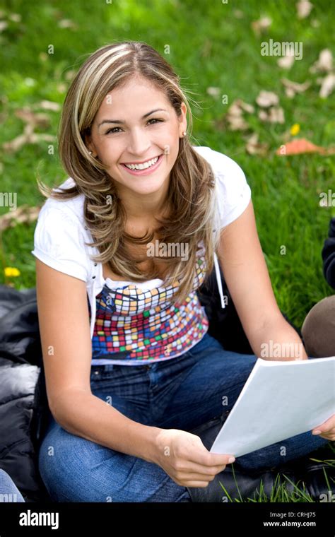 Young Pretty Coed Sitting Outdoors On The Lawn With A Notebook Stock