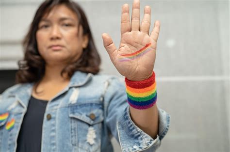 senhora asiática usando pulseiras de bandeira do arco íris símbolo do mês do orgulho lgbt