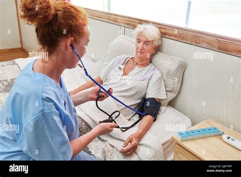 Nurse Measuring The Blood Pressure Of A Senior Citizen In A Nursing
