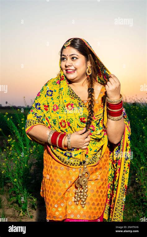 Portrait Of Beautiful Young Indian Punjabi Woman Wearing Colorful Traditional Standing At