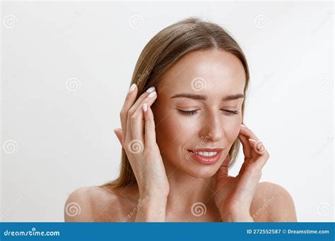 Smiling Woman Touching Her Perfect Face Over White Studio Background