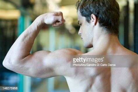 Young Man Flexing Bicep Muscles Photo Getty Images