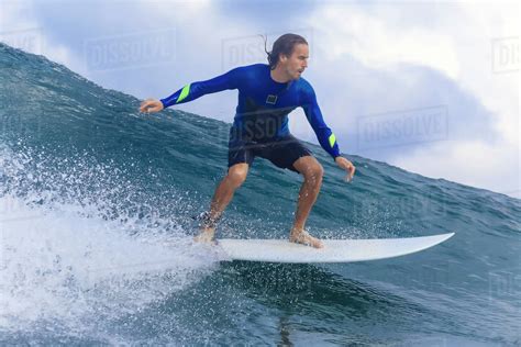 Young Man Riding Wave On Surfboard In Sea Stock Photo Dissolve