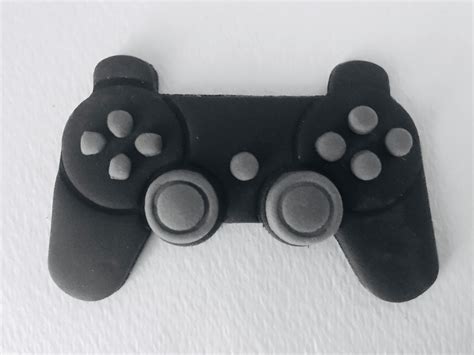 A Close Up Of A Video Game Controller On A White Surface With Two