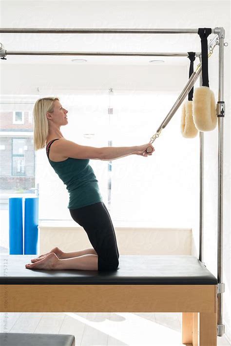 Woman Undertaking Pilates Stretching Exercise On The Trapeze Table By