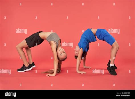 Cute Sporty Kids In Sportswear Bending Over Backwards And Smiling