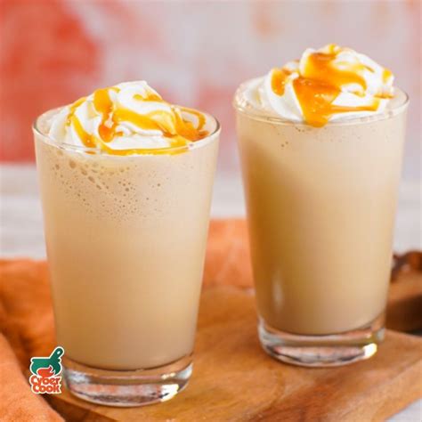 Two Glasses Filled With Dessert Sitting On Top Of A Wooden Tray