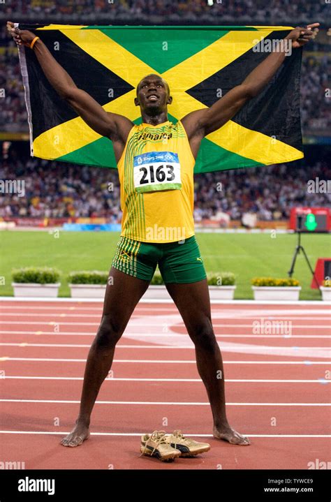 jamaica s usain bolt jubilates with his country s flag after smashing the 100m world record with