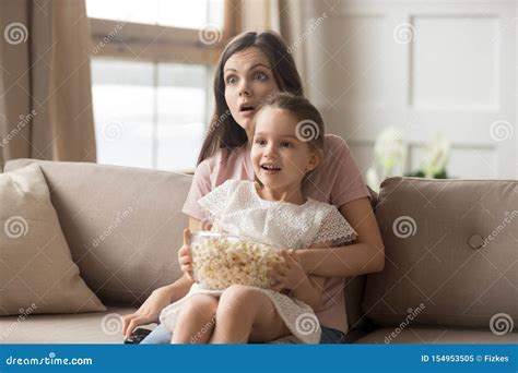 mother hold daughter on lap watching movie feels shocked stock image image of expression