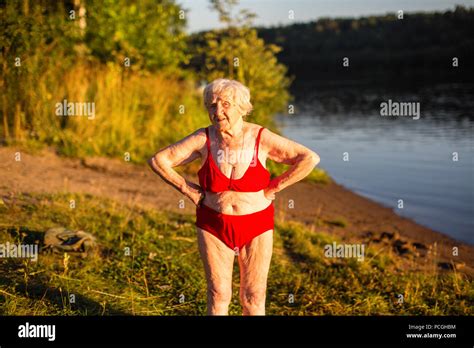 Eine ältere Frau in einem Badeanzug ist am Ufer des Flusses