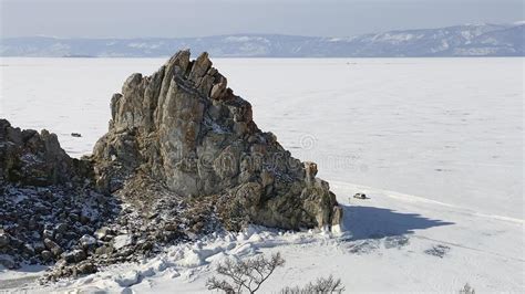 The Car Drives Along The Frozen Lake Baikal Not Far From Shamanka