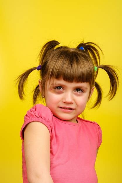 retrato de niña caucásica llorando con coletas y hematoma debajo del ojo foto premium