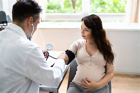 Крупный план врача мужского пола Измерение кровяного давления беременной женщины в клинике