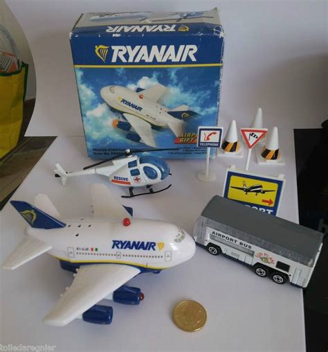 A Toy Airplane And Other Toys Are On The Table Next To A Box That Says