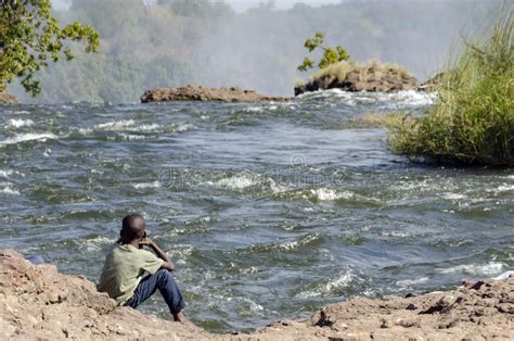 African Child Setting On Zambezi River Side On Top Of Victoria Falls
