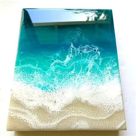 A Square Glass Plate With Blue And White Waves In The Water On Top Of It
