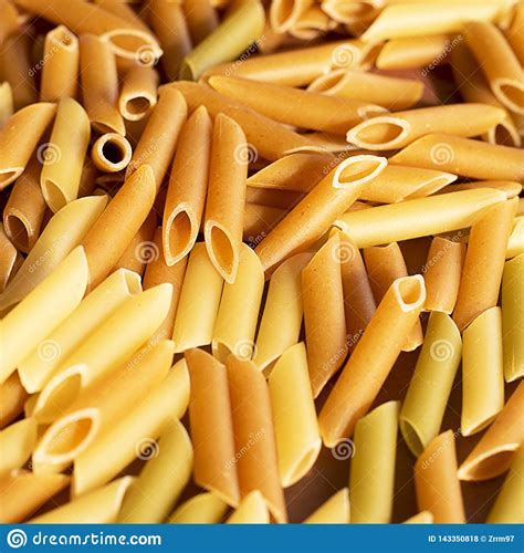 Different Pasta In The Form Of Tubes Of Brown Yellow And Green Colors