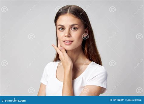 Pretty Woman Touches Her Face With Her Hand And Smiles On A Light Background Stock Image Image