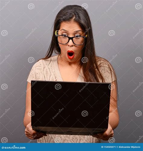 Portrait Of Woman In Shock What She Sees At Her Laptop Against Gray Background Stock Image